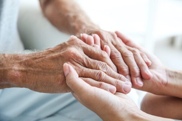 young hand holding elderly hand